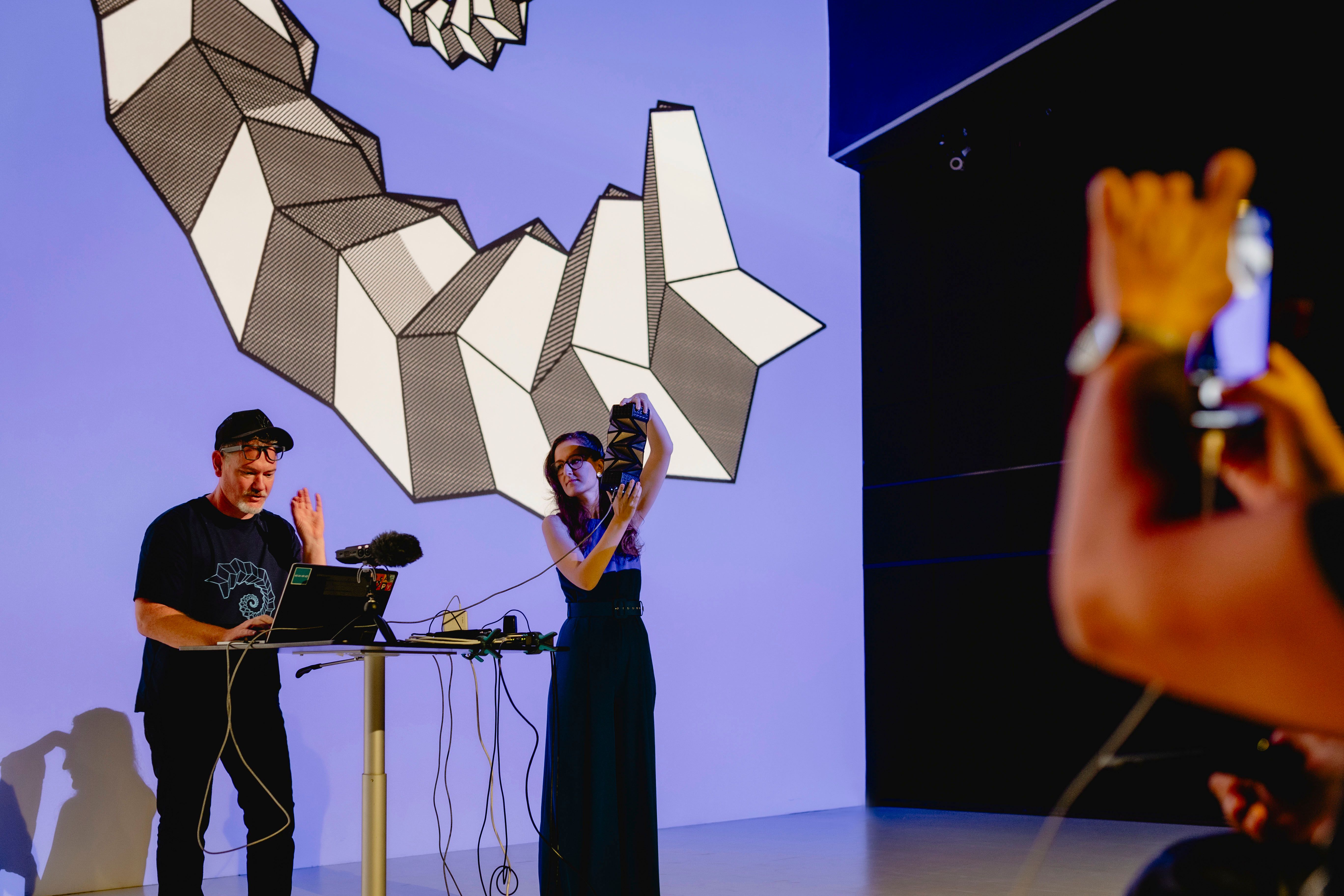 Photo of the performance 'POP: Post-Origami Punk' by Matthew Gardiner (AU), Anna Weiss (AT) and Alexandre A. Bizri (FR) at the Futurelab Night 2024